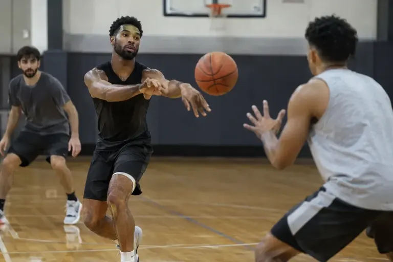 Basketball player making an unselfish pass to a teammate on an indoor amateur court, natural sporting action.