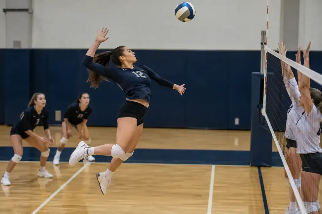 Volleyball player taking off behind the attack line on an indoor court.